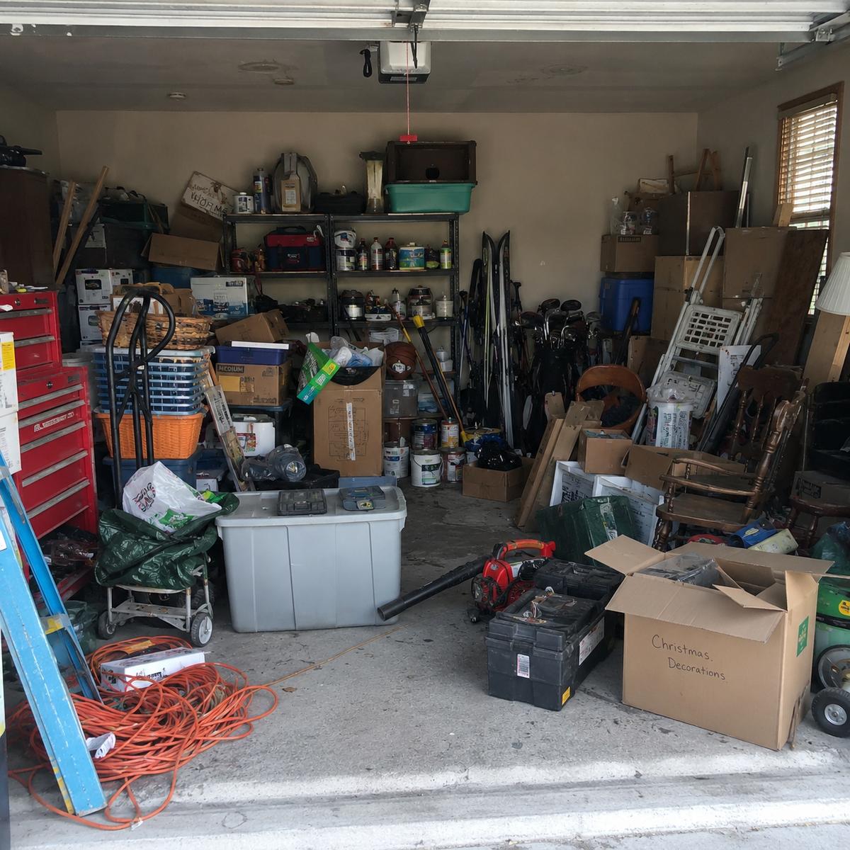 Cluttered two-car garage before cleanout